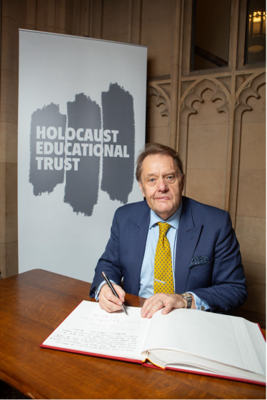 Sir John Hayes signs the Holocaust Educational Trust's Book of Commitment